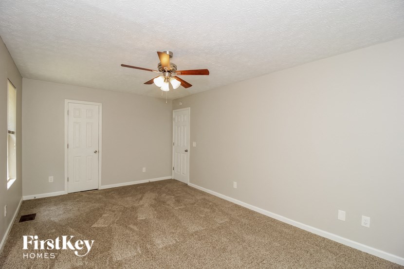 the living room of a house with a ceiling fan
