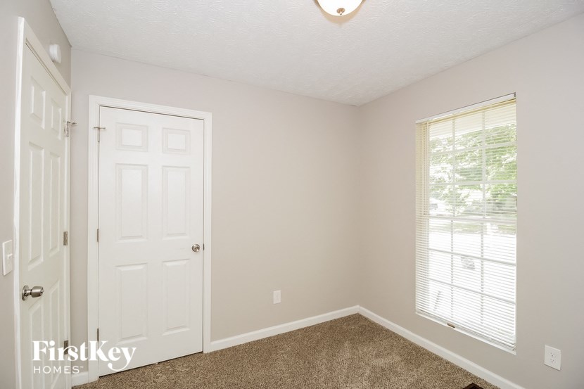 the bedroom of a home with a white door and window