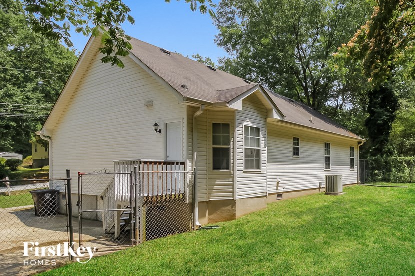 a small white house with a deck and a yard