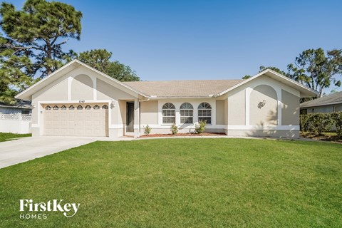 a beige house with a lawn in front of it