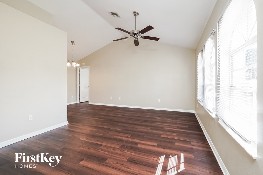 a living room with wood flooring and a ceiling fan
