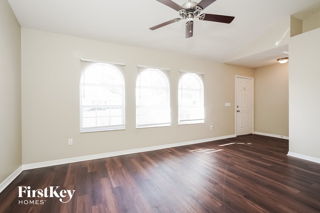 the living room with hardwood floors and a ceiling fan