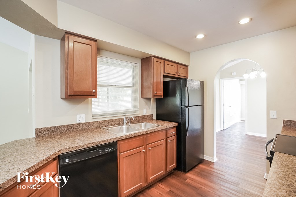a kitchen with wooden cabinets and a black refrigerator
