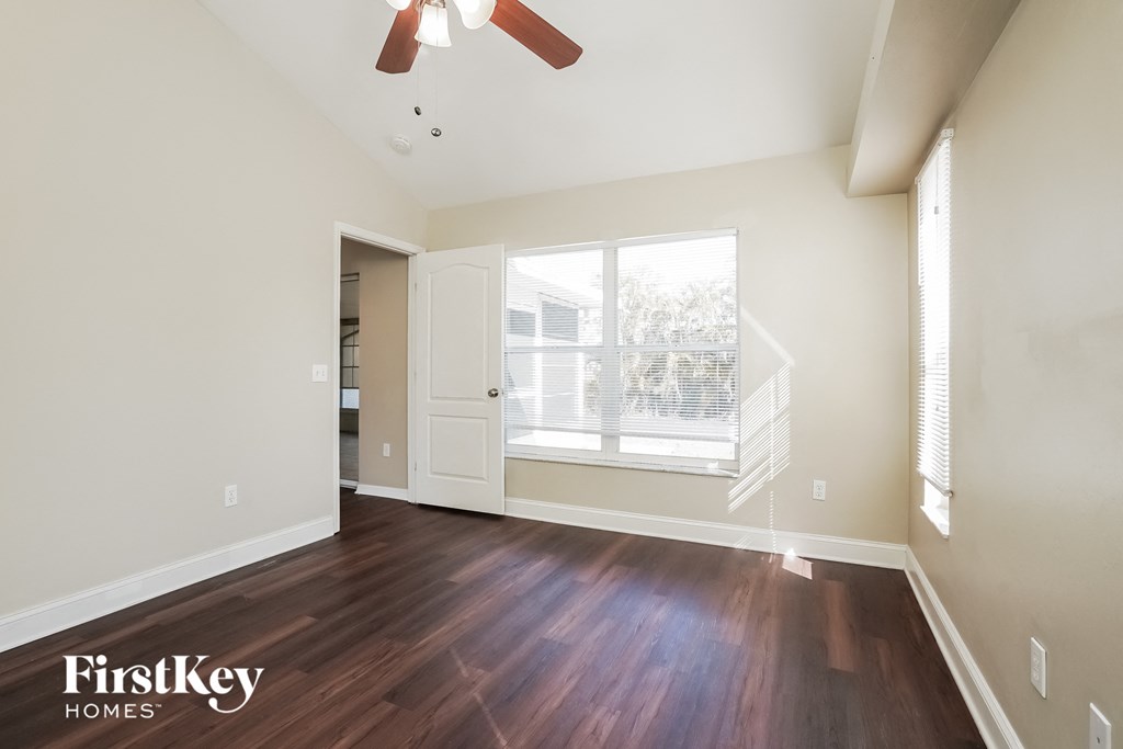 an empty living room with hardwood floors and a large window