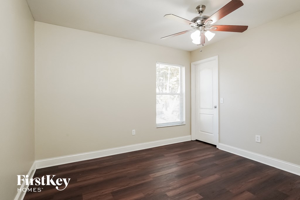 a bedroom with hardwood flooring and a ceiling fan
