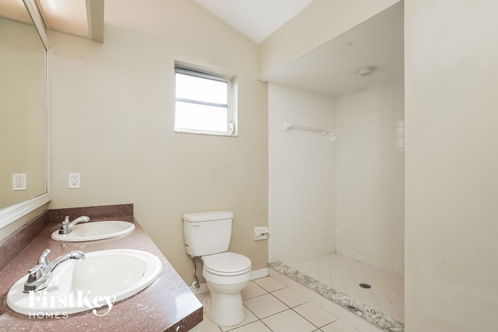 a bathroom with a toilet and a sink and a shower