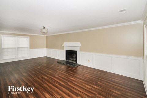 a living room with a fireplace and wooden floors