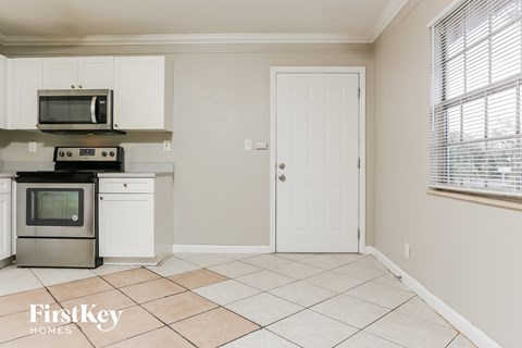 A kitchen with a white oven and microwave above it.