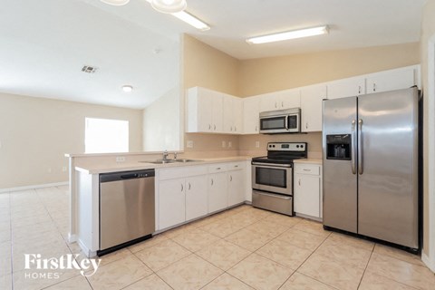 a large kitchen with stainless steel appliances and white cabinets