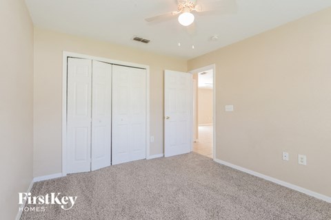 a bedroom with two closets and a ceiling fan
