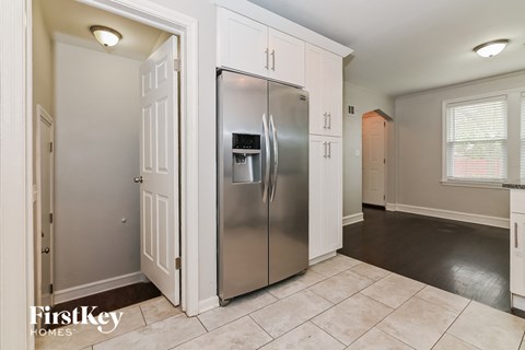 a kitchen with a stainless steel refrigerator and white cabinets
