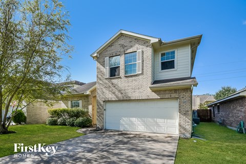 a brick house with a white garage door and a green lawn