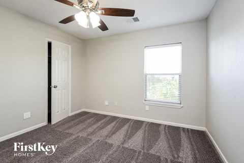 a bedroom with a ceiling fan and a window