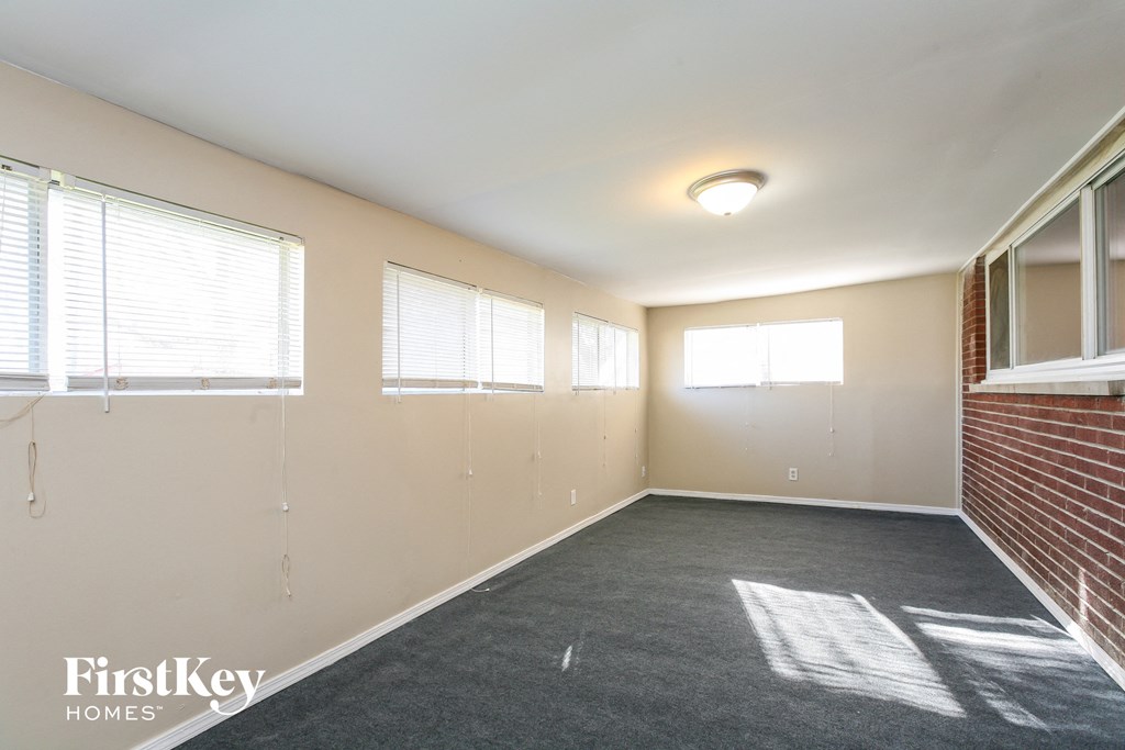 an empty room with a brick wall and windows