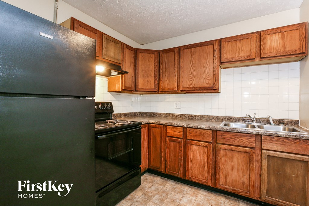 a kitchen with black appliances and wooden cabinets