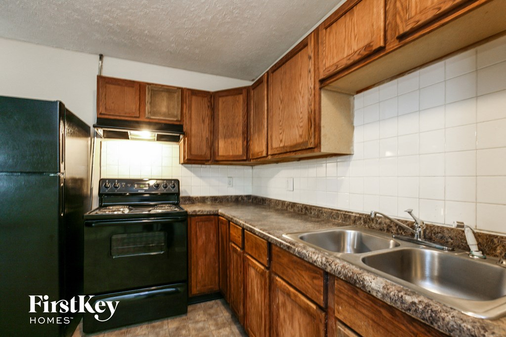 a kitchen with black appliances and wooden cabinets