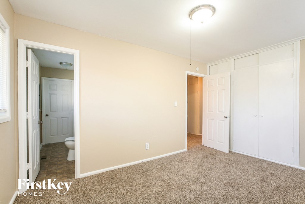 a bedroom with a closet and a door to a bathroom