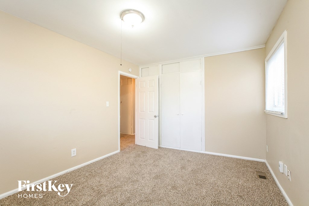 a spacious living room with carpet and a door to a closet