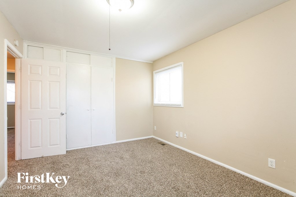 a bedroom with carpet and a white door