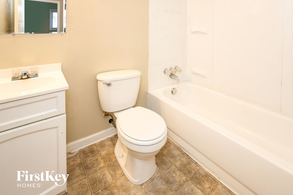 a bathroom with a toilet and a tub and a sink