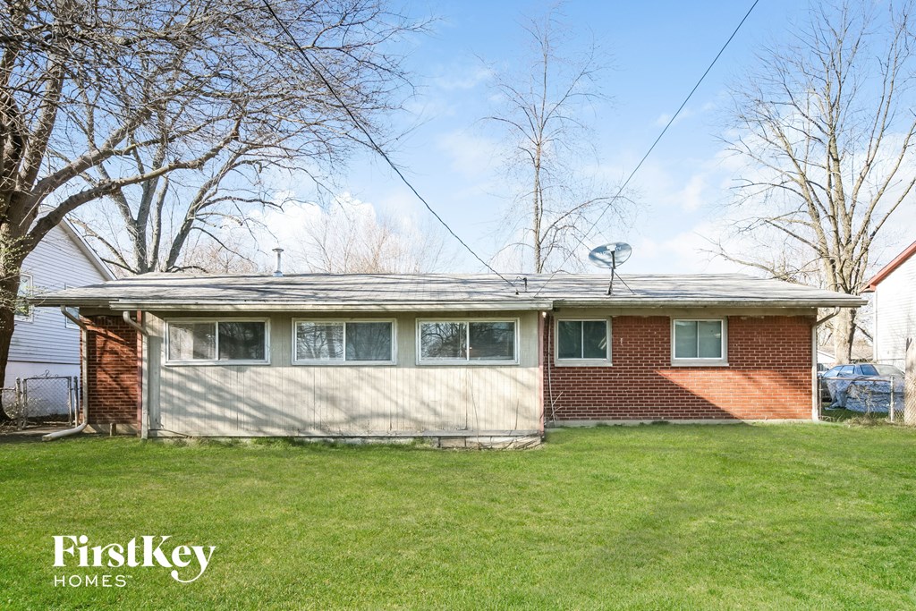 a brick house with a white garage door and a green lawn