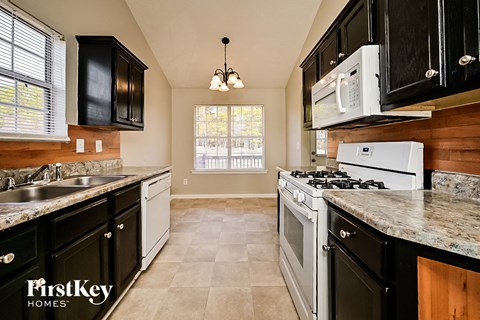 a kitchen with white appliances and black cabinets