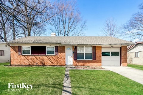 A brick house with a white door and windows is for sale.