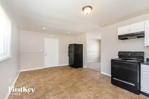 A kitchen area with a black fridge, stove and oven.
