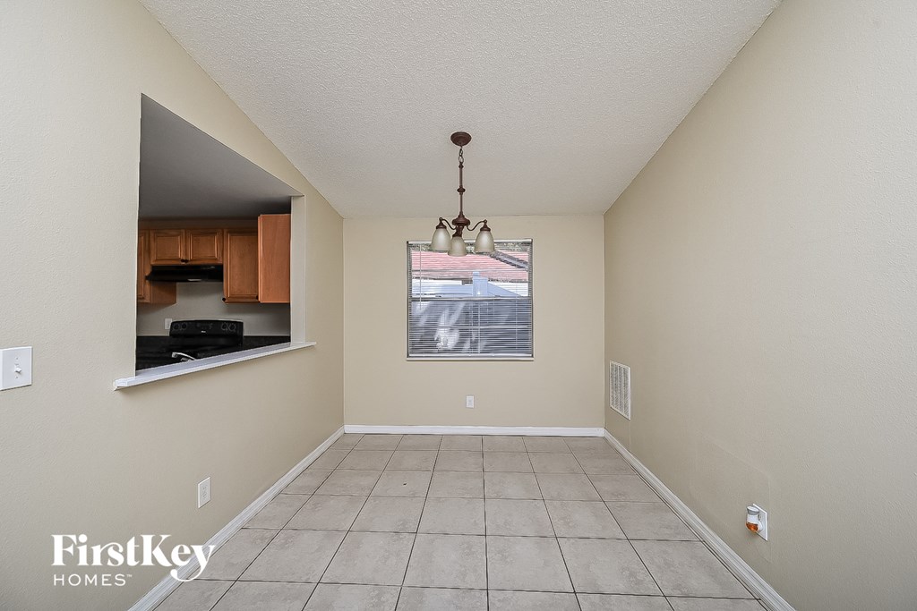 an empty kitchen and dining room with a tile floor