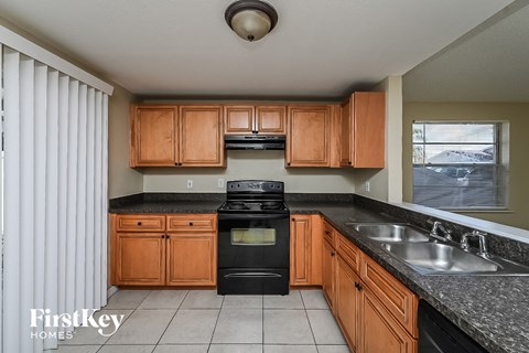 a kitchen with black appliances and wooden cabinets