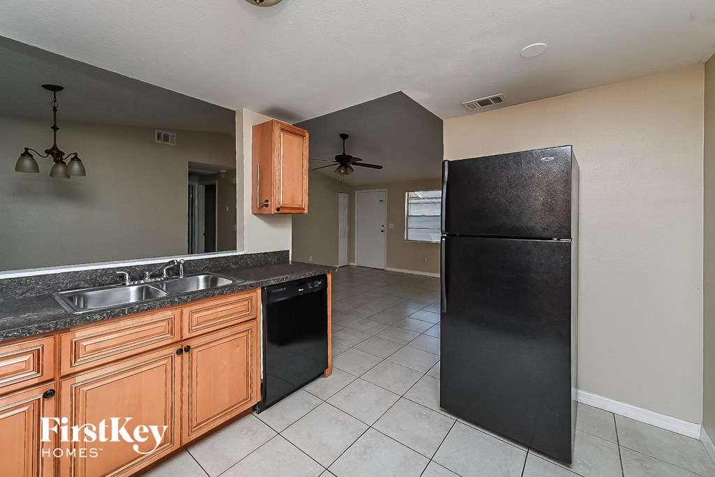 a kitchen with a black refrigerator and a sink