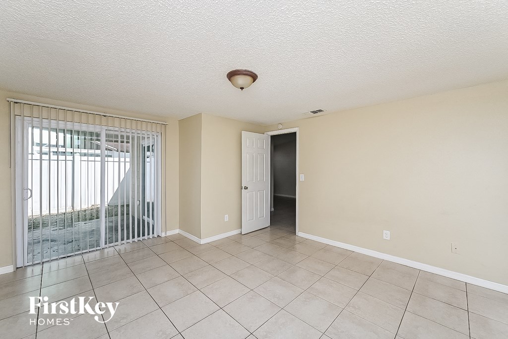 a spacious living room with a sliding glass door to a patio
