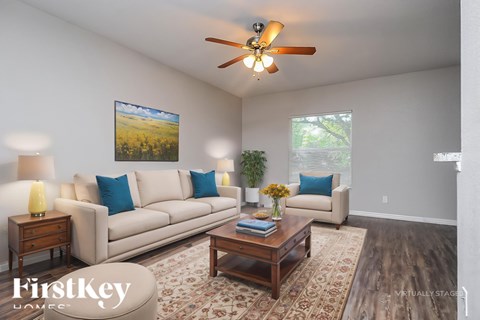 A living room with a couch, a coffee table, and a painting on the wall.
