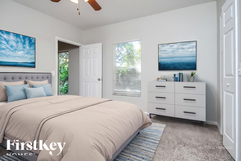 A bedroom with a large bed, a dresser, and two pictures on the wall.