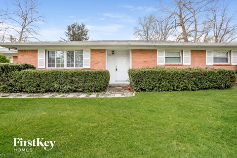 A house with a white door and a hedge in front.