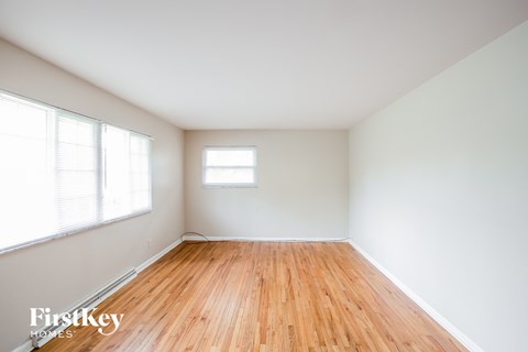 Empty room with wooden floor and white walls.