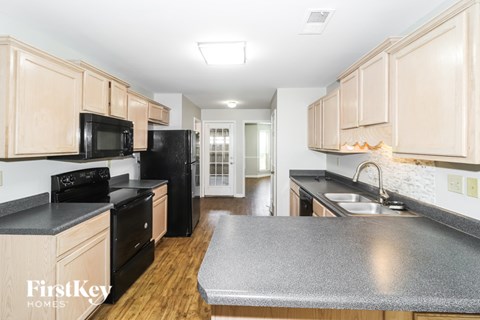 A kitchen with wooden cabinets and black appliances.