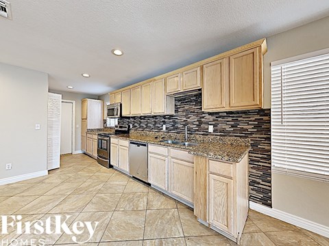 A kitchen with wooden cabinets and a granite countertop.