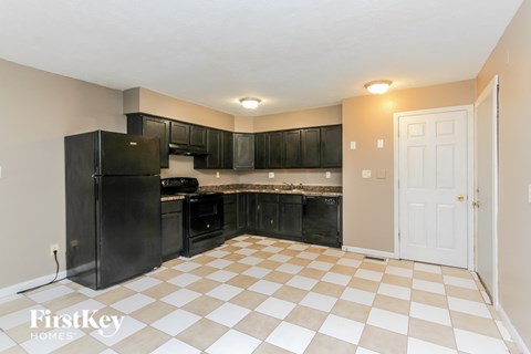 A kitchen with black cabinets and a checkered floor.