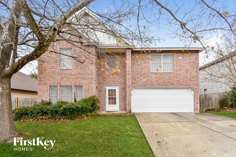 the front of a brick house with a white garage door