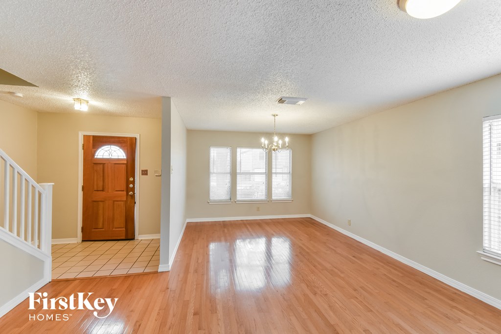 an empty living room with wooden floors and a wooden door