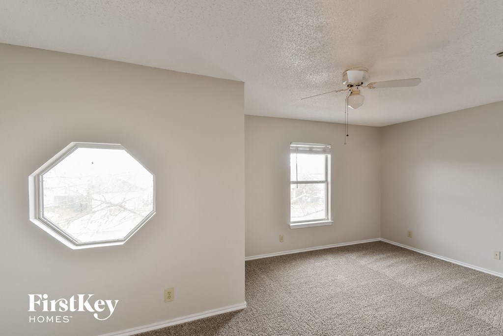 a bedroom with a ceiling fan and a window