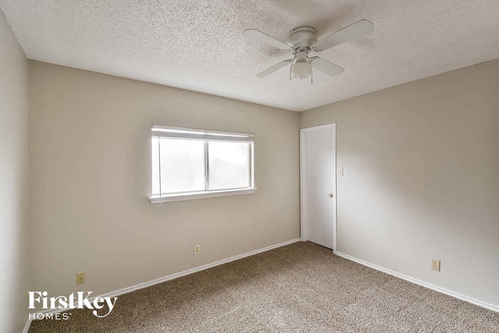 a bedroom with a ceiling fan and a window