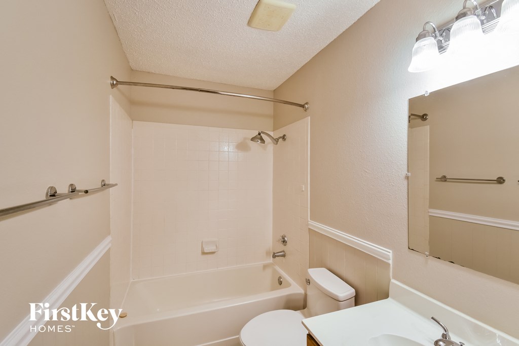 a bathroom with a tub and a sink and a toilet