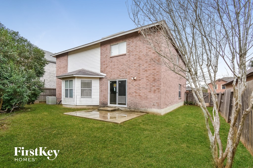 a small brick house with a yard and a backdoor