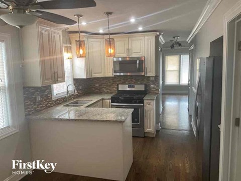 A kitchen with a marble countertop and wooden cabinets.