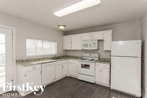 a white kitchen with white appliances and white cabinets