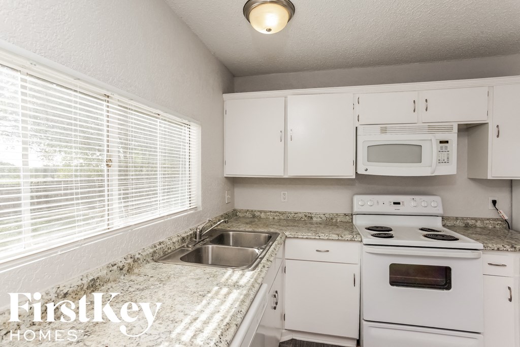 a kitchen with white appliances and granite counter tops