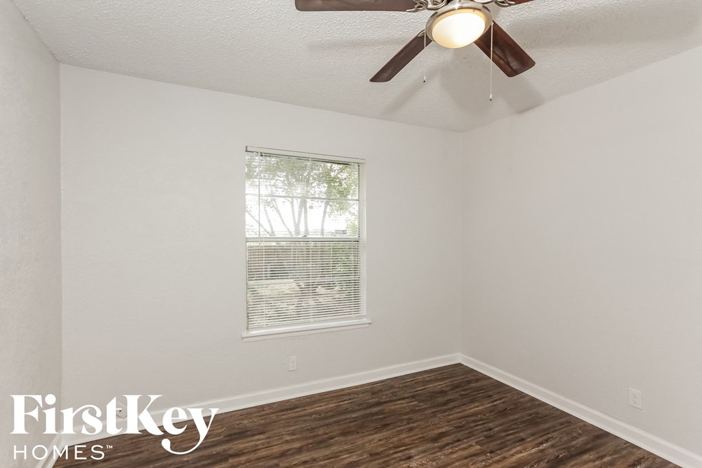 a bedroom with a ceiling fan and a window