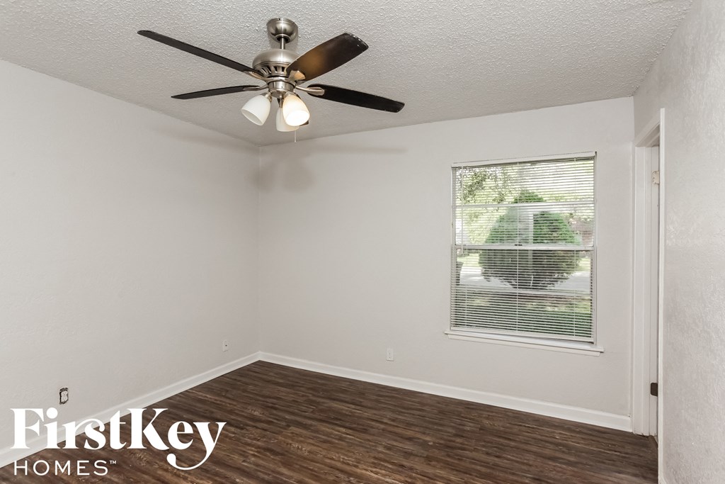 a living room with a ceiling fan and a window